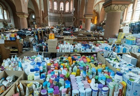 Sachspenden stapeln sich in einem Kirchenraum