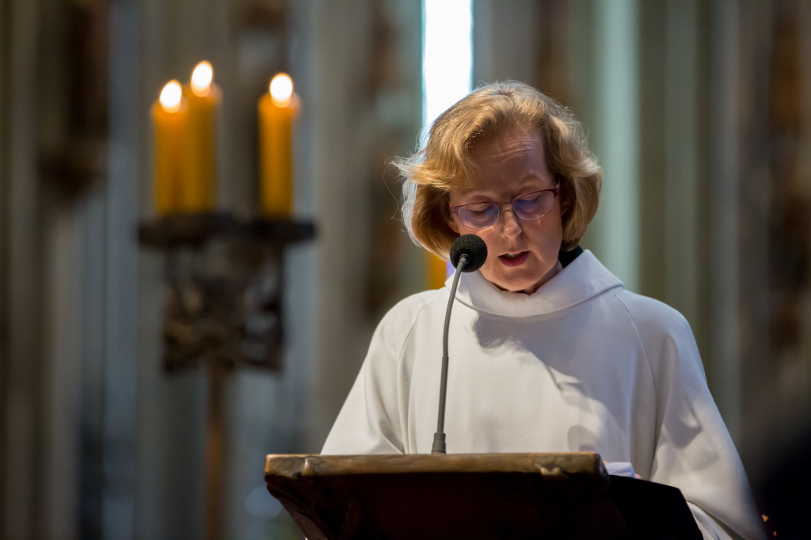 Eine Lektorin in liturgischem Gewand verkündet eine Lesung