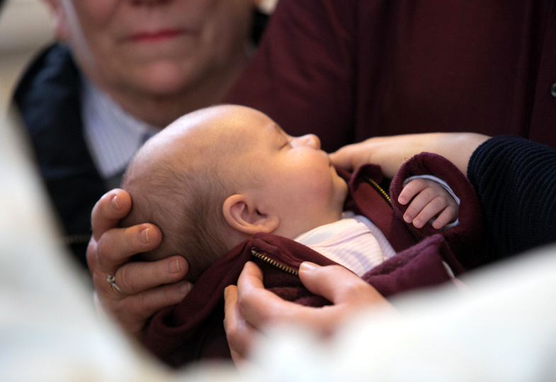 Verwandte legen ihrem Baby die Hand an den Kopf