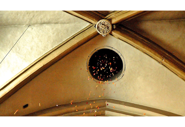 Rosenblätter regnen durch eine Öffnung im Kirchendach