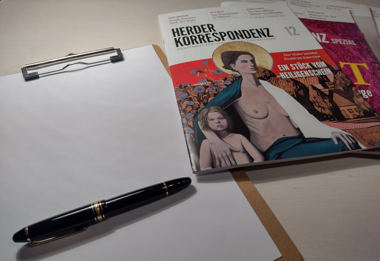 Zeitschriften und Block und Stift liegen auf einem Schreibtisch