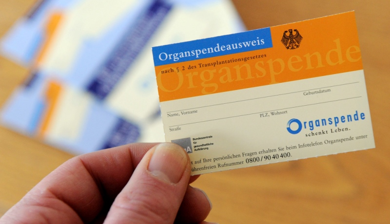 Hand hält Organspendeausweis