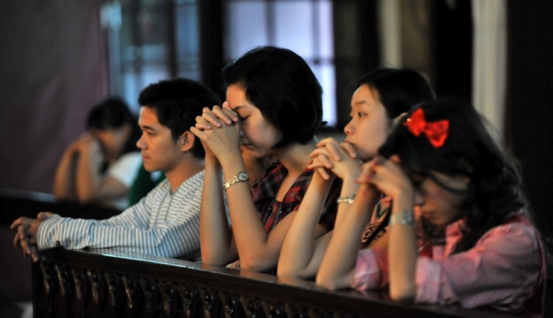 Chinesische Katholiken beten in einer Kirche