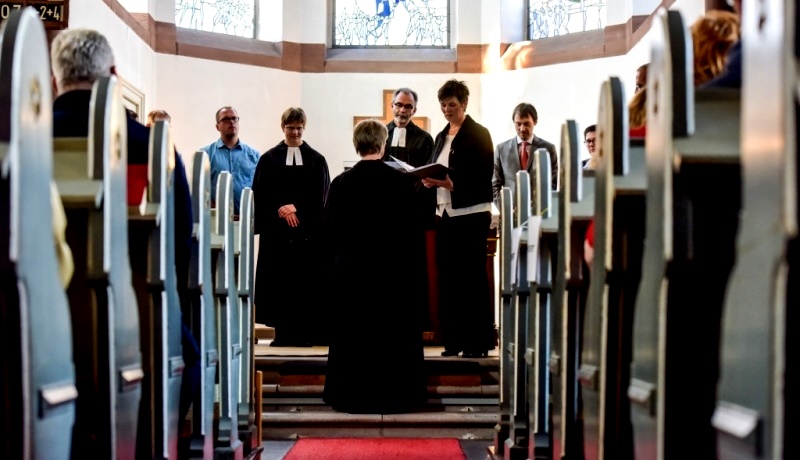 Eine Frau wird in einer evangelischen Kirche ordiniert.