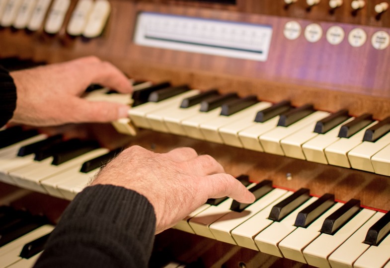 Jemand sitzt an der Orgel.