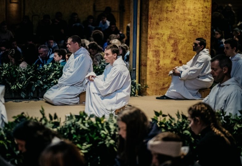 Betende Taizé-Brüder und junge Menschen in Taizé