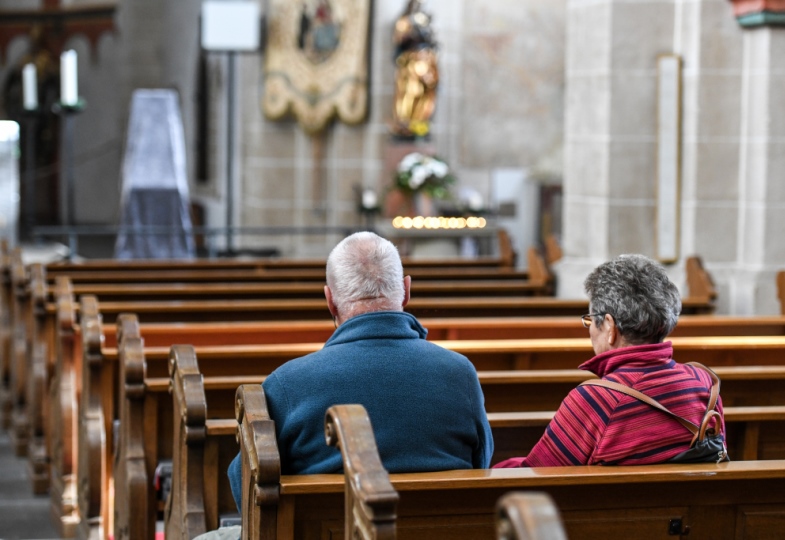 Ein Mann und eine Frau sitzen in einer Kirche.