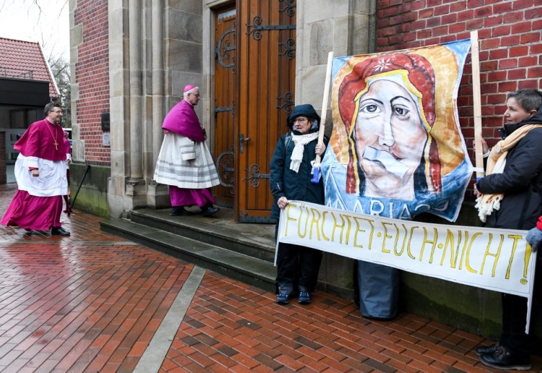 Frauen demonstrieren vor einer Kirche für mehr Partizpation.