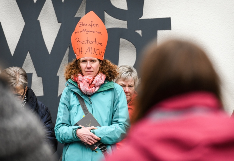 Frau mit gebastelter Mitra fordert Macht in der Kirche.