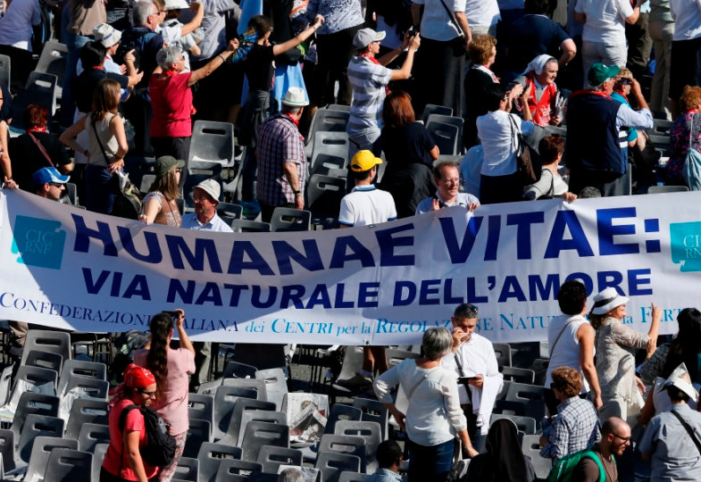 Menschen auf dem Petersplatz halten ein Plakat mit der Aufschrift "Humanae Vitae" hoch.