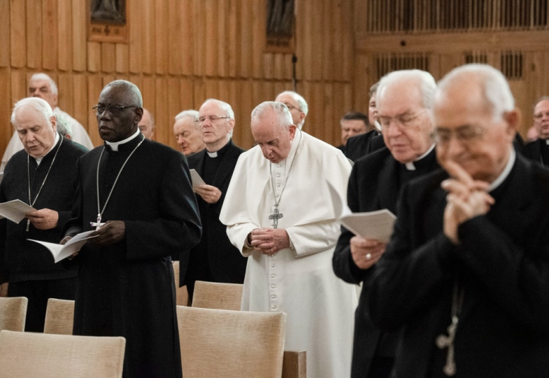 Papst Franziskus und Mitglieder der Kurie beten.