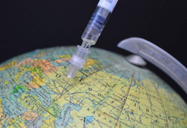 Weltkugel mit Impfspritze