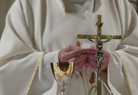 Ein Priester hält eine Hostie in der Hand