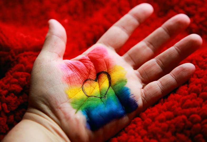 Herz auf Hand mit Regenbogen