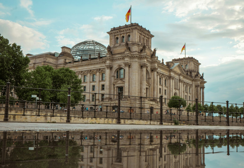 Das Reichstagsgebäude spiegelt sich in einer Pfütze