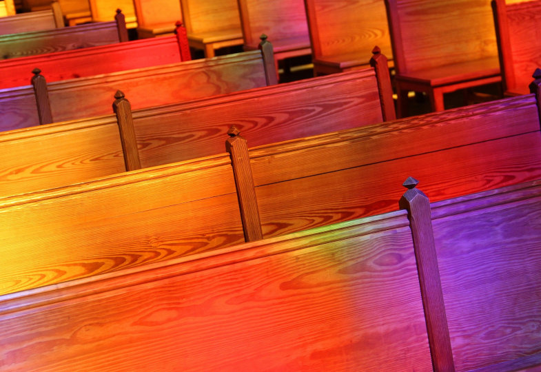 Buntes Licht auf leeren Kirchenbänken