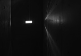 Eine einzelne Lampe brennt in einem dunklen Flur