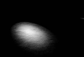 Ein schwacher Lichtkegel in einem dunklen Raum