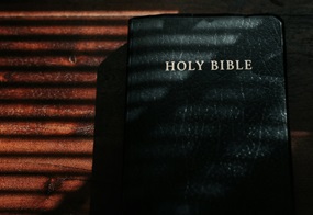Eine Bibel im schwarzen Ledereinband liegt auf einem Tisch