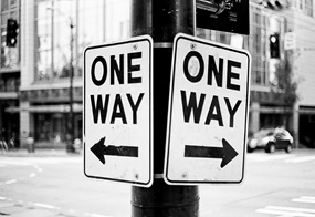 Zwei Einbahnstraßenschilder zeigen in verschiedene Richtungen