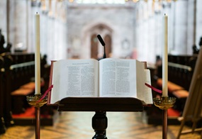 Eine aufgeschlagenen Bibel liegt am Ambo in einer Kirche