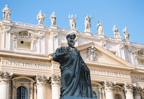 Eine Statue von Petrus steht vor dem Petersdom in Rom