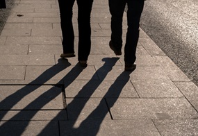 Zwei Paar Beine und Füße gehen auf einer Straße