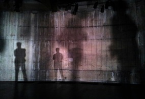 An einer Wand sieht man Schatten von Menschen