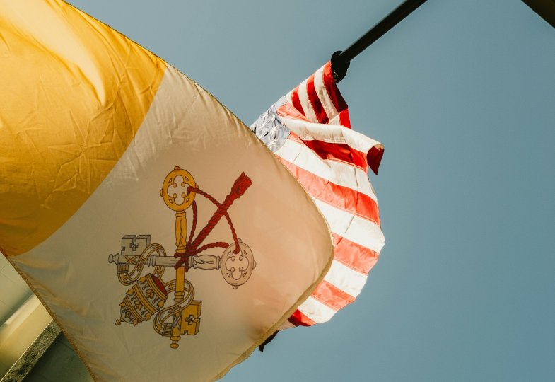 Eine Flagge des Vatikans und der USA wehen im Wind