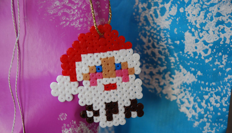 Der Kopf des Weihnachtsmanns aus Bügelperlen als Anhänger.