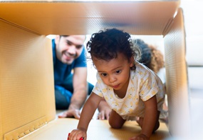 Ein Kind krabbelt in einen Karton. 