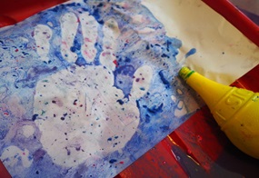 Ein Bild aus Wasserfarben zeigt einen Handabdruck.