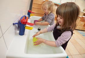 Kinder sammeln Wasser in Becher
