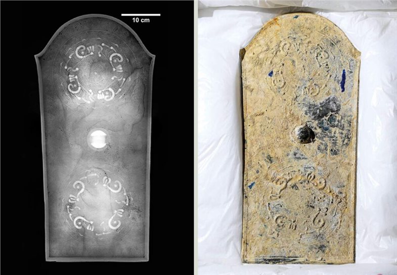 Foto und Röntgenbild des Bronzespiegels. Der obere Teil des Spiegels ist abgerundet, während der Rest eckig ist. In der Mitte befindet sich eine kleine Erhebung, ähnlich wie ein Schildbuckel, flankiert von zwei im Kreis angeordneten sich wiederholenden Mustern.