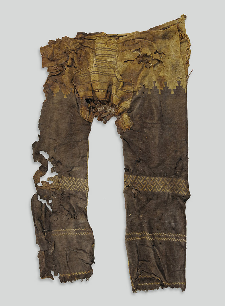 Alte, stark beschädigte Hose mit geometrischen Mustern und sichtbaren Löchern