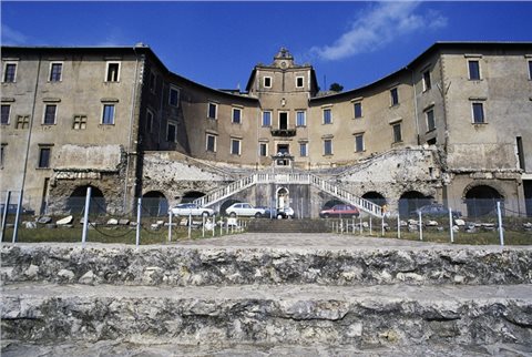 Zu sehen ist der heutige Zustand des Heiligtums. Der obere Bau wurde in der Neuzeit in einem Palast verbaut. Die Fassade folgt dabei noch den antiken Mauern.