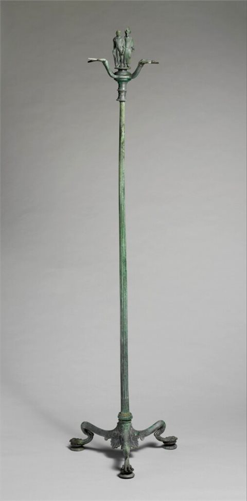 Der hohe Kandelaber ist mit zwei gewandeten Figuren verziert, die unter Verwendung von Kerzen angeleuchtet werden würden.