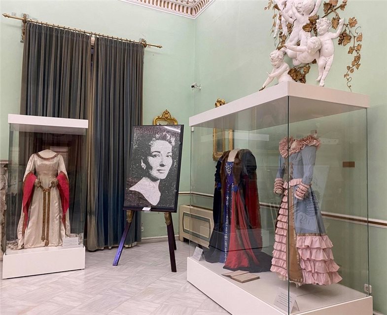 Blick in die Ausstellung. Zu sehen sind zwei Kostüme der Sängerin Maria Callas sowie ein weiteres Porträt.