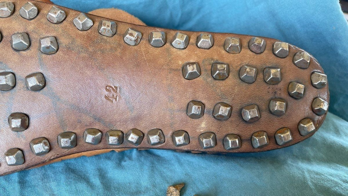 Unterseite einer Schuhsohle, in der zahlreiche Schuhnägel eingeschlagen sind.