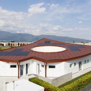 Flachdach mit roten Ziegel und flachen Tegosolar-Paneelen.