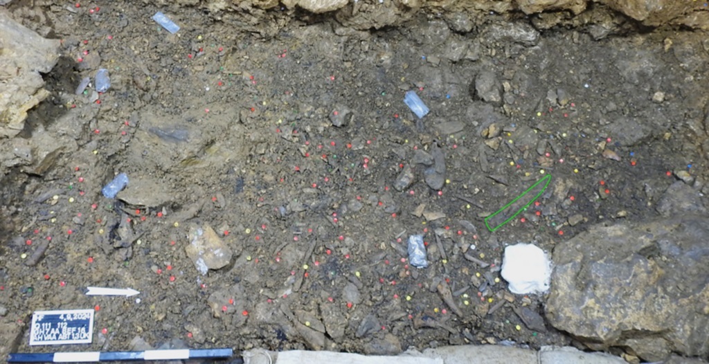 Foto der Ausgrabungsfläche in der Höhle Hohle Fels. Eingezeichnet ist die Fundlage des Mammutelfenbeinmeißels