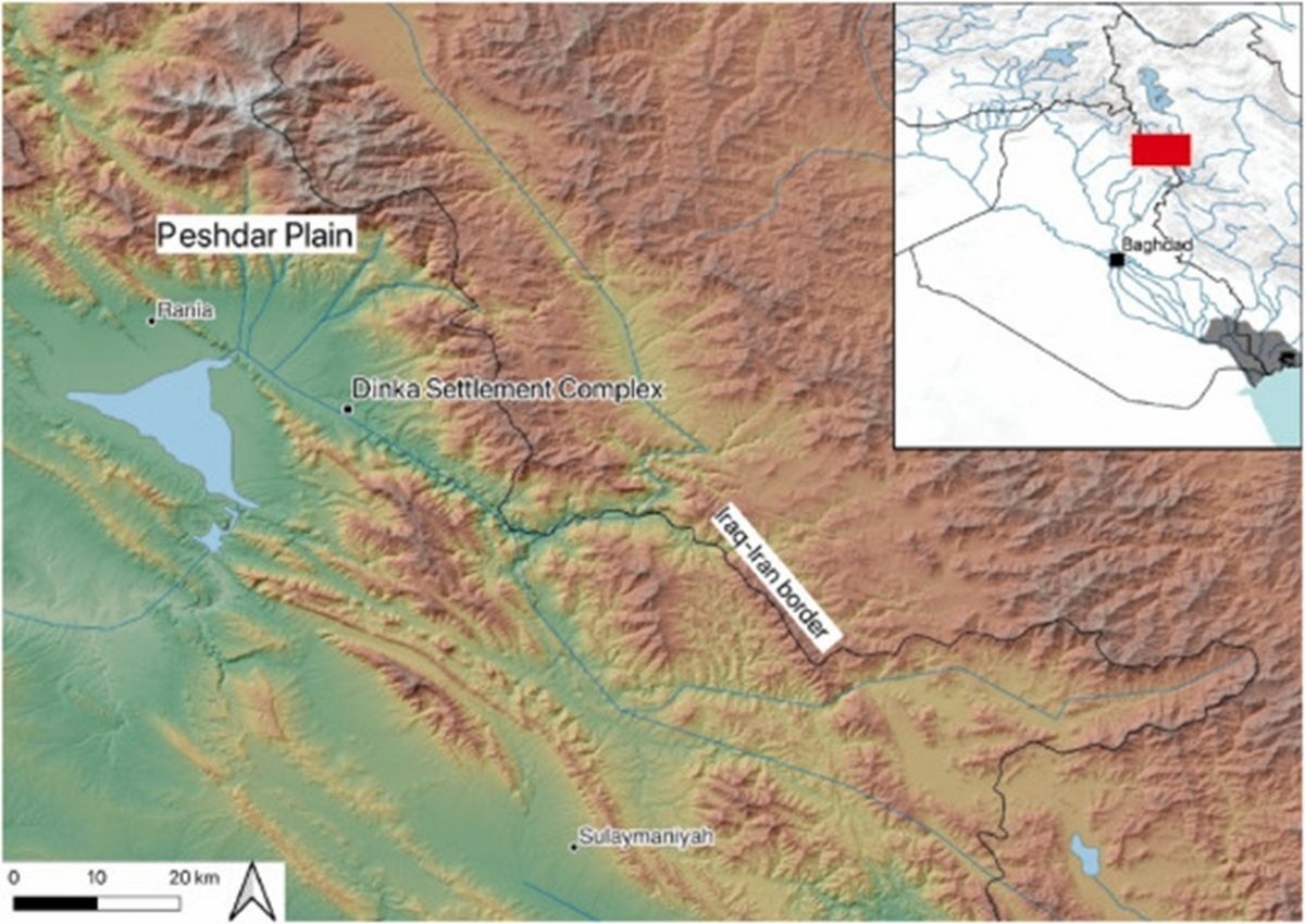Karte mit topografischer Darstellung einer Region, die Gebirgszüge und Täler zeigt. Beschriftungen markieren die Peshdar-Ebene, den Dinka-Siedlungskomplex, die Zagros-Grenze sowie die Stadt Sulaymaniyah. Oben rechts befindet sich eine kleine Übersichtskarte, die den Standort der Region im Irak zeigt, mit einer roten Markierung im Nordosten des Landes. Die Karte enthält eine Maßstabsleiste von 0 bis 20 Kilometern und eine Nordpfeil-Symbolik zur Orientierung.