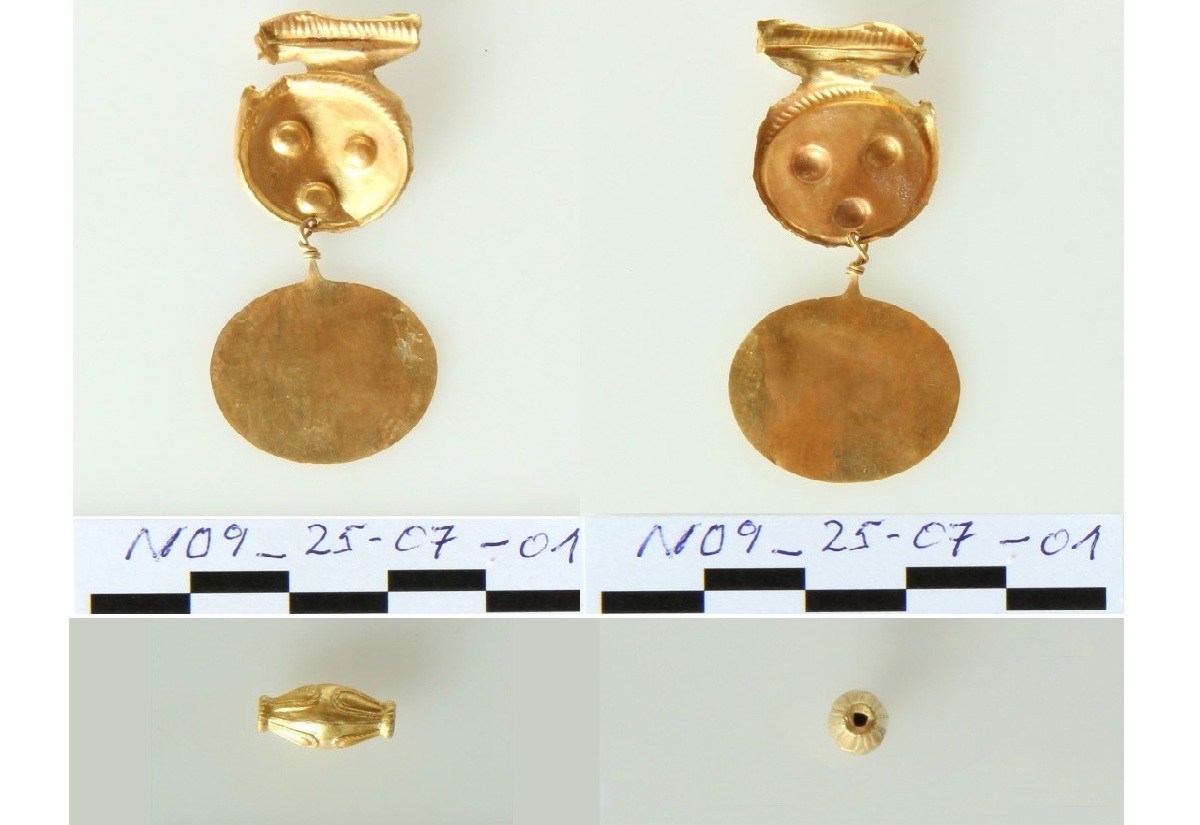 Zwei goldene Schmuckstücke mit runder Scheibe und verziertem Aufsatz liegen nebeneinander auf einer hellen Fläche. Darunter ist eine goldene, konisch geformte Perle in Seitenansicht und in Draufsicht abgebildet.