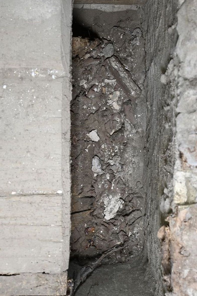 Im freien Bereich zwischen Holzkiste (links) und Sarkophagtrog (rechts) sind erste Funde -  vor allem Textilfragmente - zu erkennen.