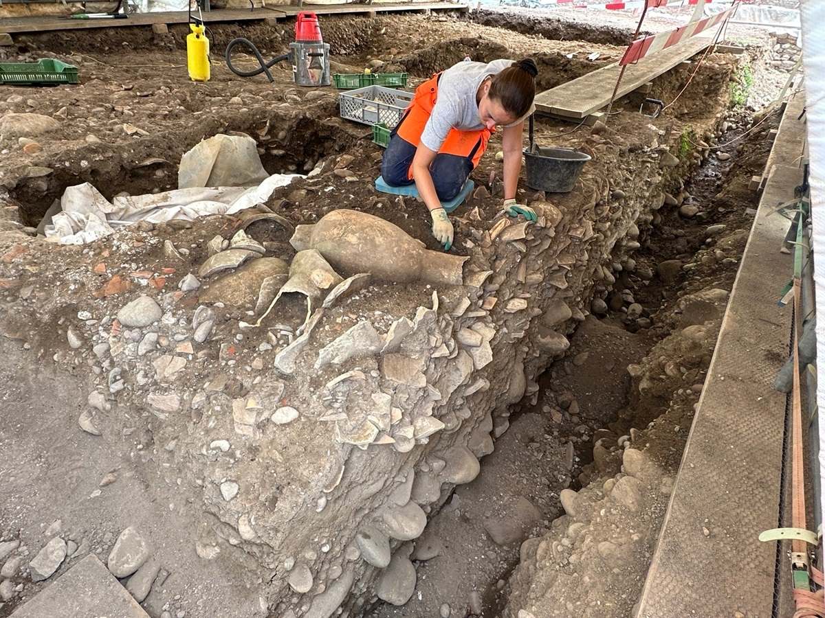 Eine Archäologin legt eine Amphore frei