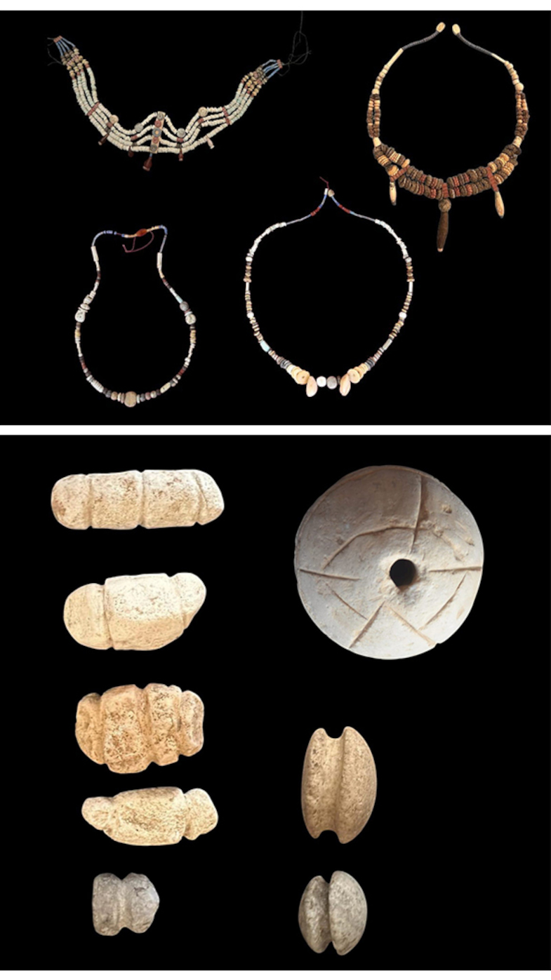 Oben sind drei Halsketten aus unterschiedlichen Materialien auf schwarzem Hintergrund angeordnet. Die Ketten bestehen aus kleinen Perlen, größeren Steinen und länglichen Anhängern. Darunter sind mehrere archäologische Fundstücke zu sehen, darunter längliche, grob bearbeitete Objekte aus hellem Stein sowie eine runde Scheibe mit einem Loch in der Mitte. Alle Gegenstände sind einzeln und klar voneinander abgegrenzt dargestellt.