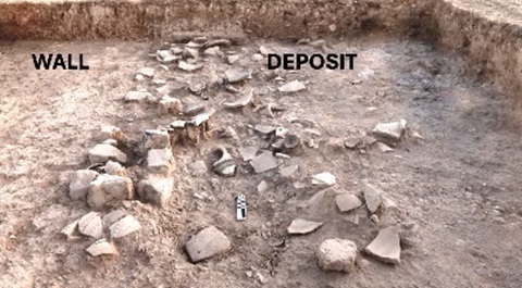 Ausgrabungsstätte mit erkennbaren Wand- und Fundschichtbereichen, beschriftet mit 'WALL' und 'DEPOSIT'