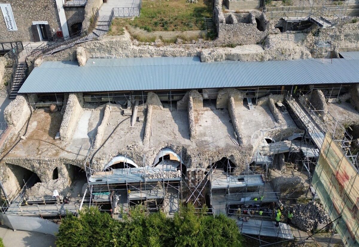 Archäologische Ausgrabungsstätte in Pompeji mit freigelegten Gebäuderuinen und Schutzdach