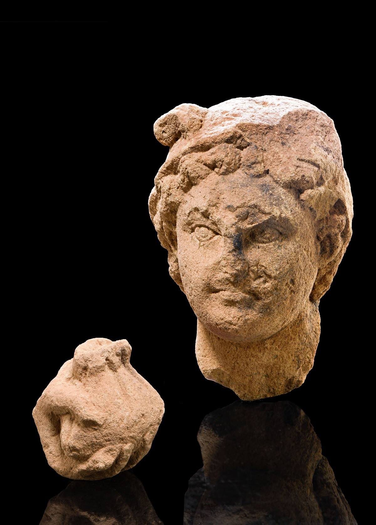 Kopf und Hand der im Tempel aufgestellten Statue des Gottes Merkur mit seinen Erkennungsmerkmalen Flügelhaube und Geldbeutel