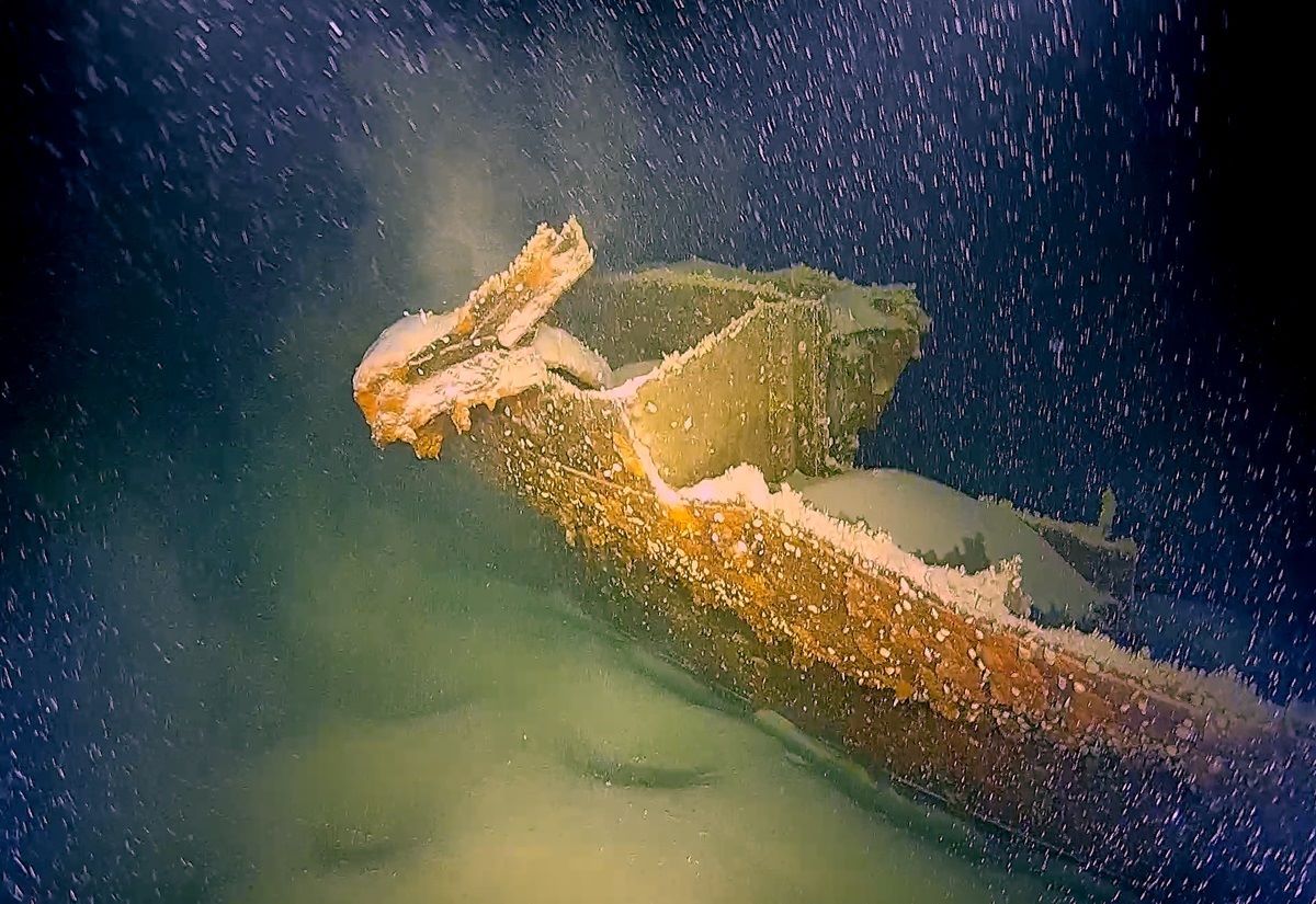 Unterwasseraufnahme eines mit Sediment bedeckten, verfallenen Schiffswracks am Bodensee